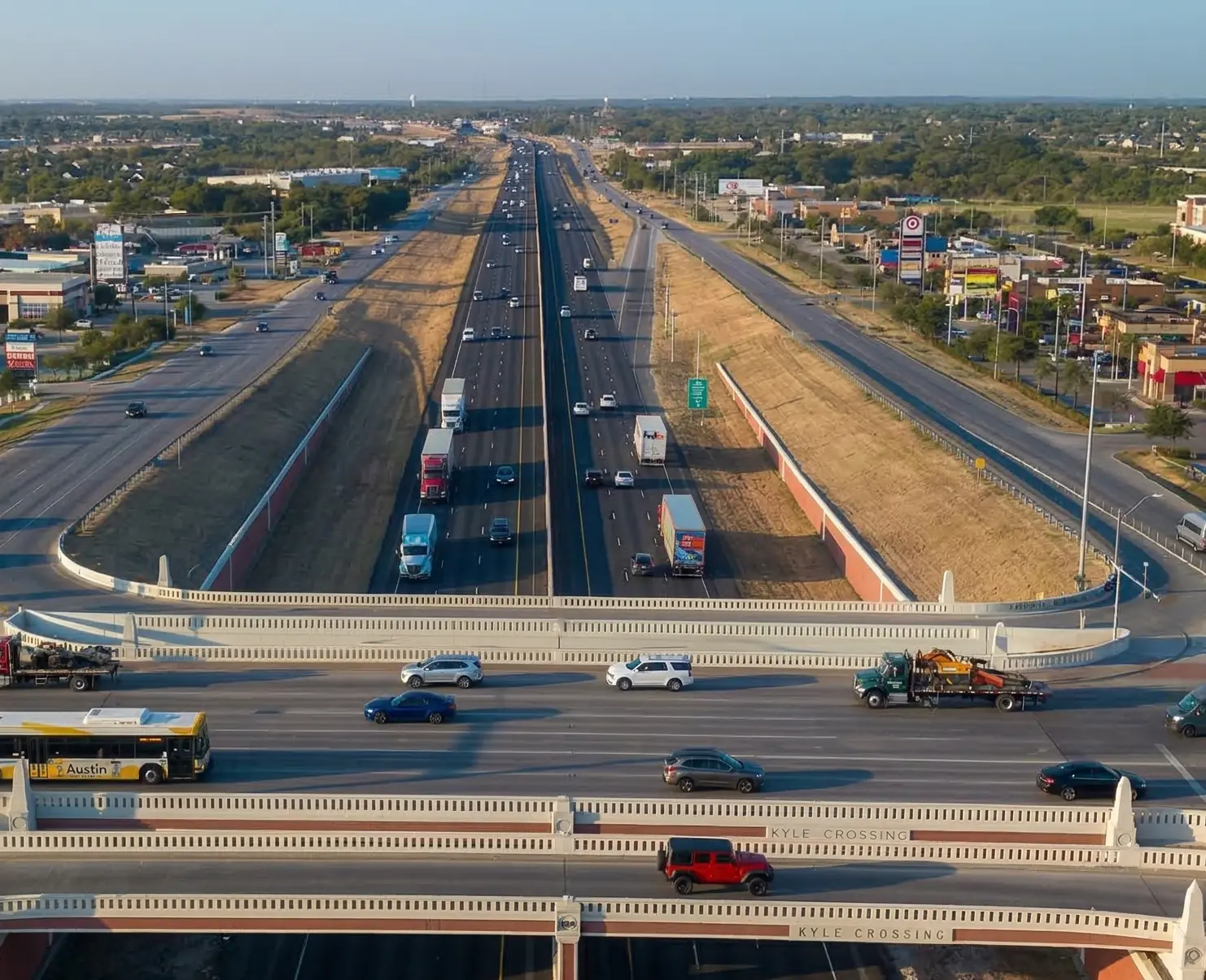 A highway interchange with multiple lanes of traffic and vehicles under clear skies.