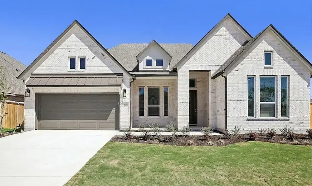 A modern, single-story white brick house with a two-car garage and manicured lawn.